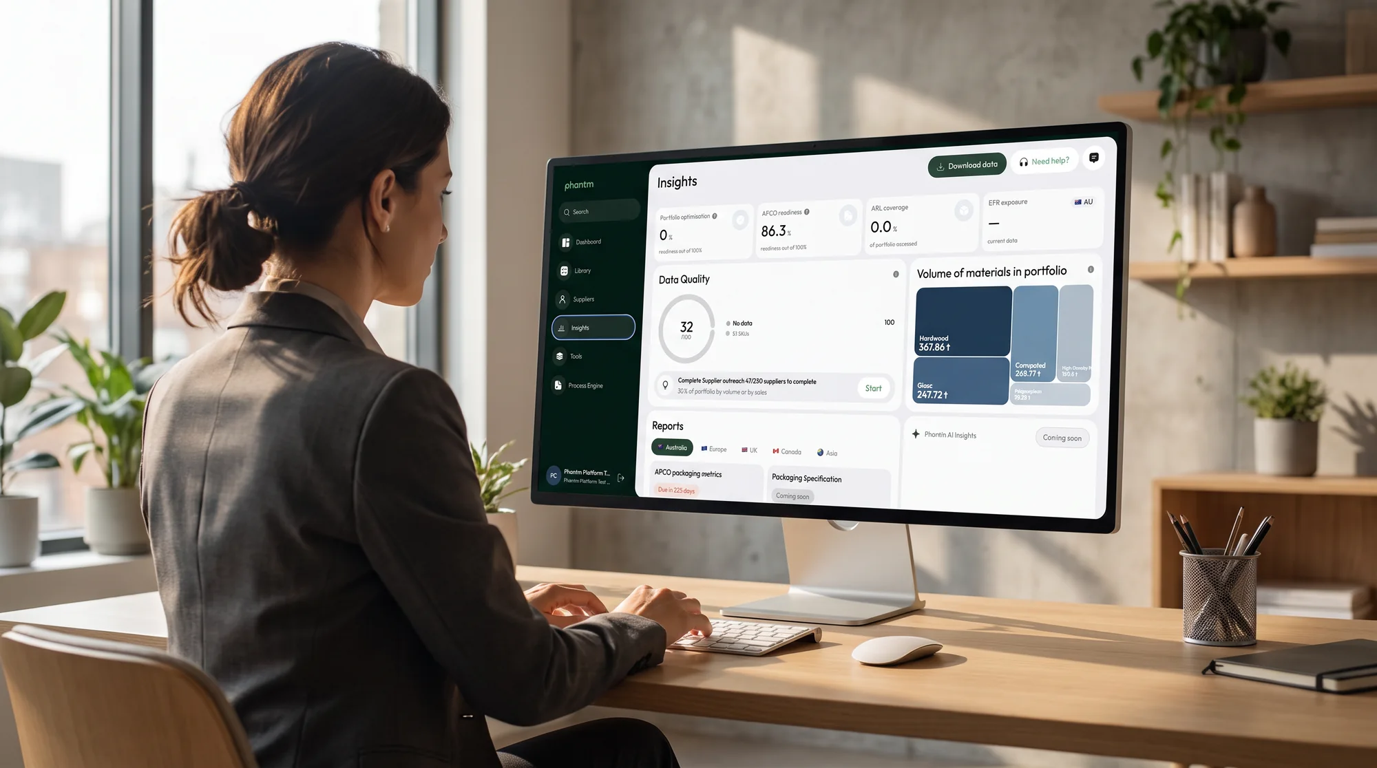A packaging lead reviewing the Phantm Insights dashboard on a large monitor at a bright office desk.